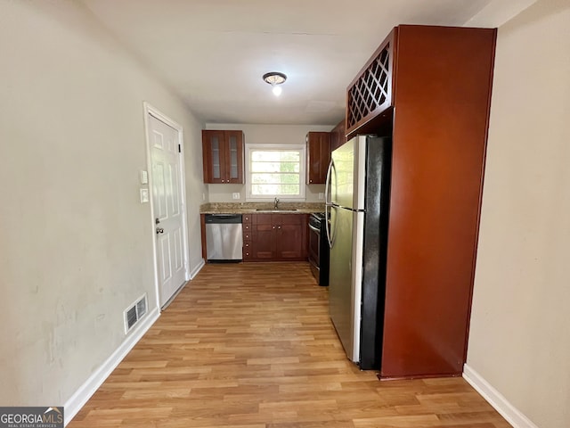 kitchen featuring light wood-type flooring, appliances with stainless steel finishes, and sink