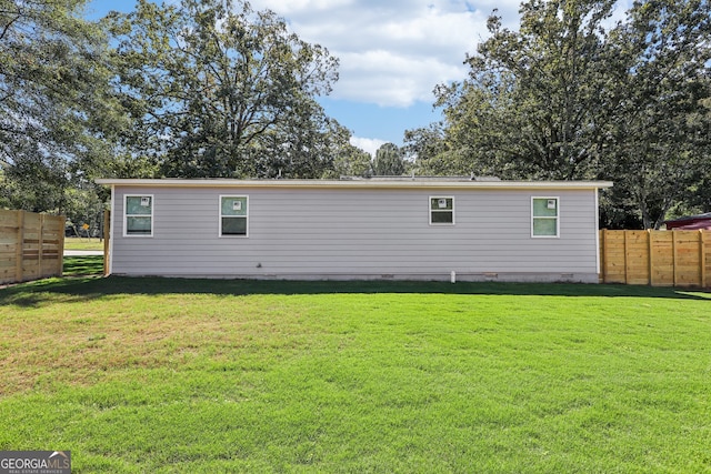 rear view of house featuring a yard