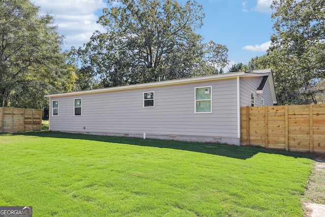 view of side of home with a yard