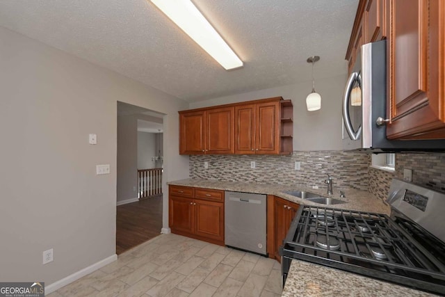 kitchen featuring tasteful backsplash, hanging light fixtures, appliances with stainless steel finishes, light hardwood / wood-style floors, and sink