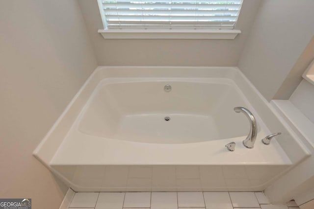 bathroom with a tub to relax in and tile patterned floors