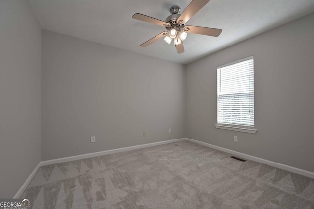 carpeted spare room with ceiling fan