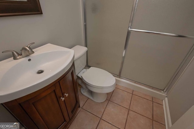 bathroom featuring vanity, tile patterned flooring, toilet, and an enclosed shower