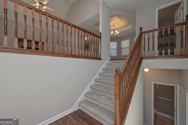 stairs featuring hardwood / wood-style flooring and an inviting chandelier