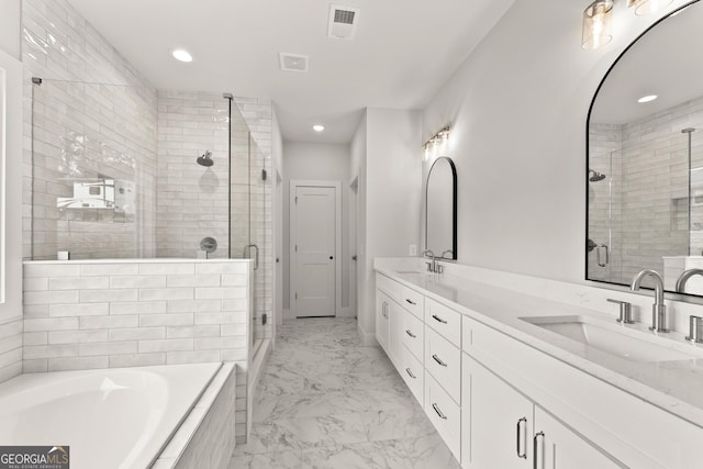 bathroom featuring vanity and independent shower and bath