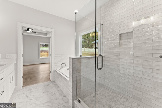 bathroom with independent shower and bath, ceiling fan, vanity, and wood-type flooring