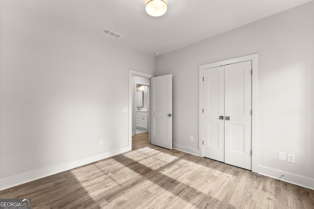 unfurnished bedroom featuring a closet and light hardwood / wood-style floors