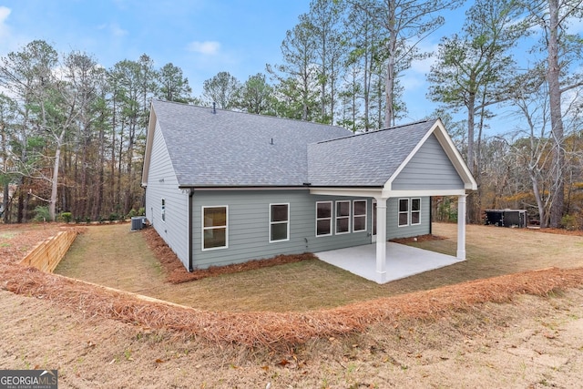 rear view of property featuring central AC, a yard, and a patio