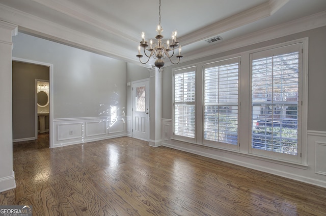 spare room featuring dark hardwood / wood-style flooring, a tray ceiling, an inviting chandelier, and crown molding