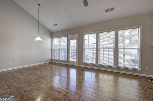 empty room with vaulted ceiling and dark wood-type flooring