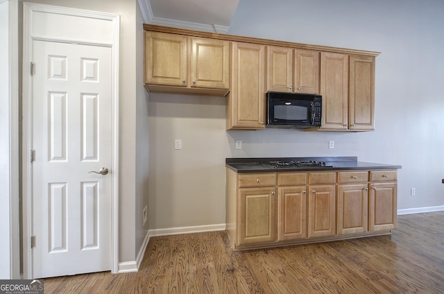 kitchen with crown molding, black appliances, and wood-type flooring