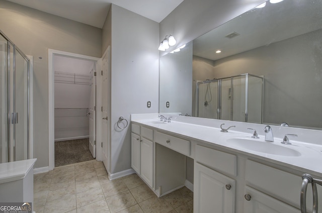 bathroom featuring a shower with door and vanity