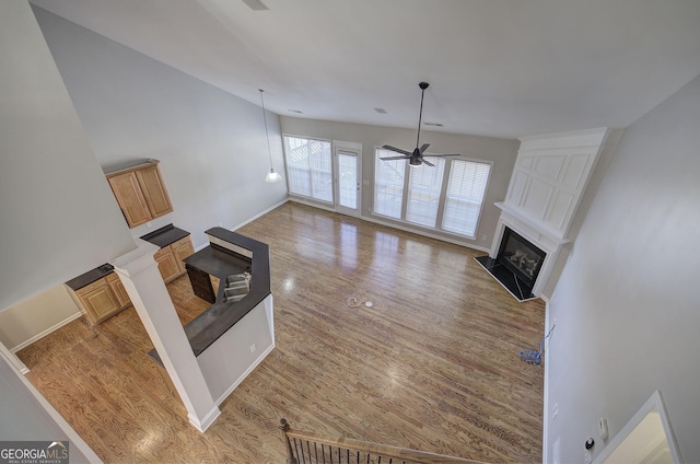 unfurnished living room with a high ceiling and ceiling fan