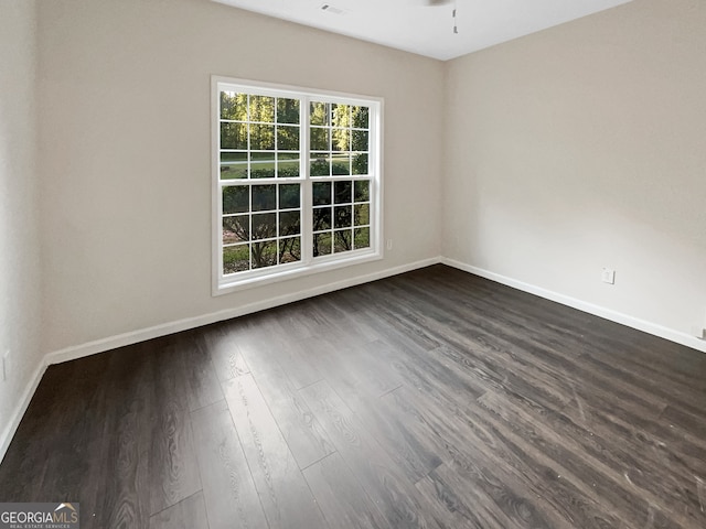 empty room with dark wood-type flooring and ceiling fan