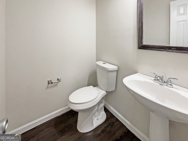 bathroom with toilet, hardwood / wood-style floors, and sink