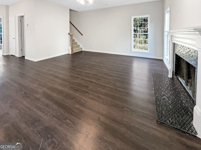 unfurnished living room with dark wood-type flooring