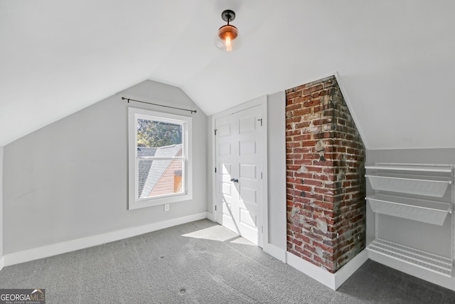 additional living space with vaulted ceiling and carpet flooring