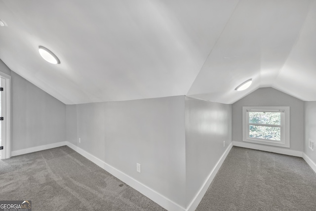 bonus room with light carpet and lofted ceiling