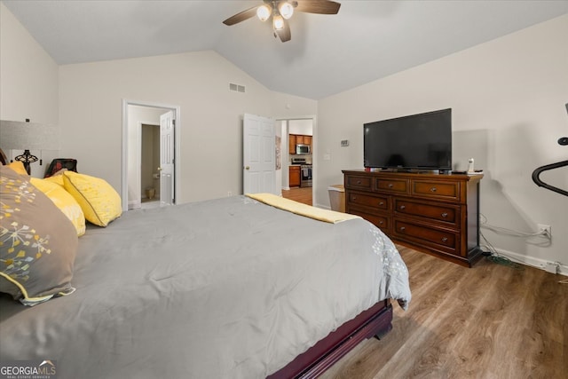 bedroom with hardwood / wood-style floors, vaulted ceiling, and ceiling fan