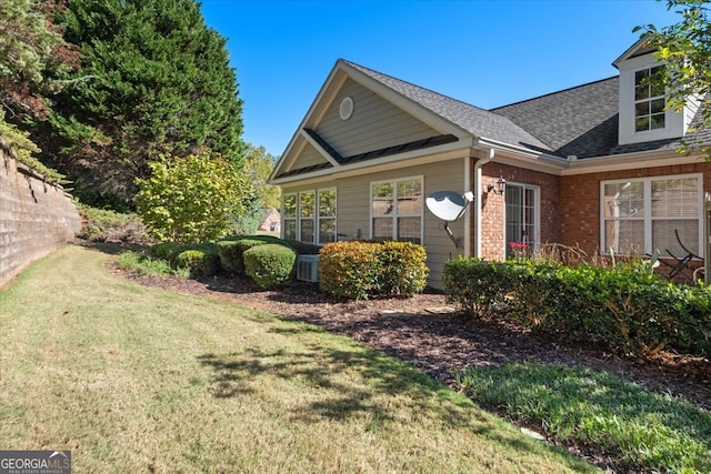 view of home's exterior featuring central AC and a yard