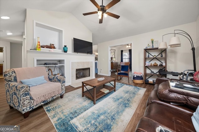 living room with hardwood / wood-style floors, ceiling fan, a fireplace, and vaulted ceiling