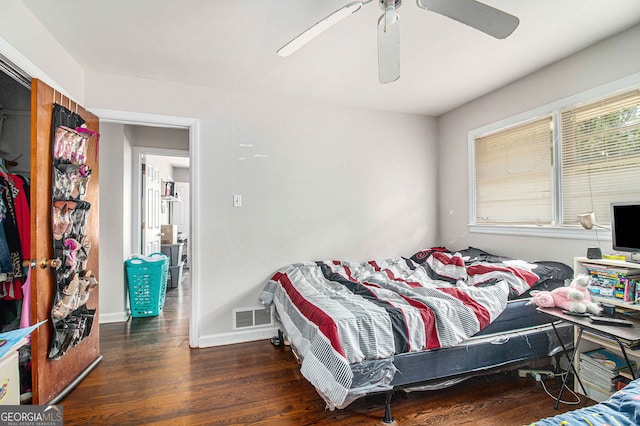 bedroom with dark hardwood / wood-style flooring and ceiling fan