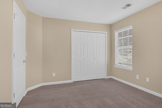 unfurnished bedroom featuring carpet floors and a closet