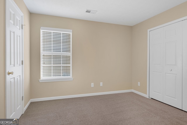 unfurnished bedroom featuring carpet and a closet