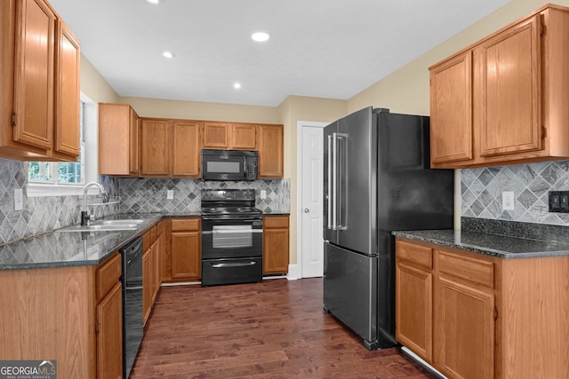 kitchen with black appliances, sink, backsplash, dark hardwood / wood-style flooring, and dark stone countertops