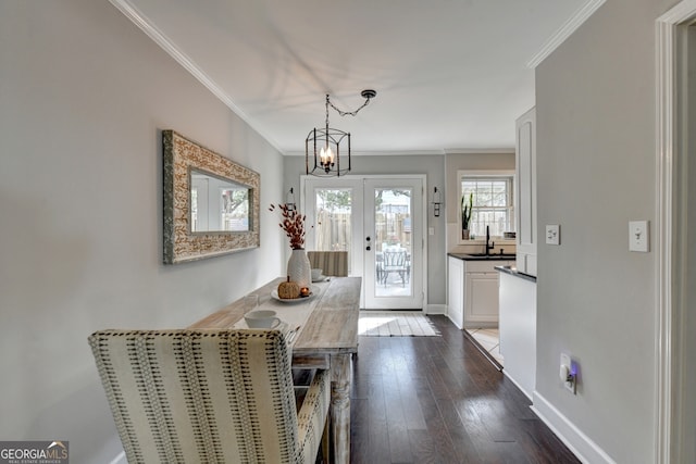 doorway to outside with a chandelier, dark wood-type flooring, crown molding, french doors, and sink