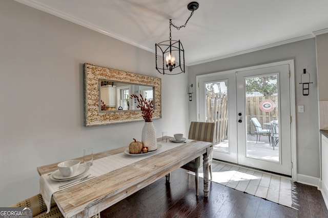 dining room with french doors, crown molding, hardwood / wood-style flooring, and a notable chandelier