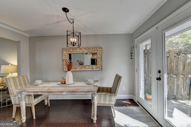 dining space featuring crown molding, hardwood / wood-style flooring, and a chandelier