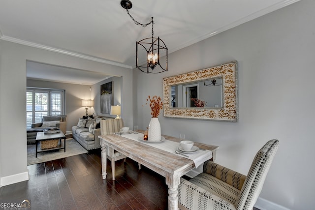 dining area with crown molding, dark hardwood / wood-style flooring, and an inviting chandelier