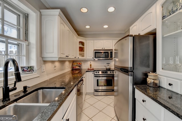 kitchen with white cabinetry, stainless steel appliances, tasteful backsplash, and sink