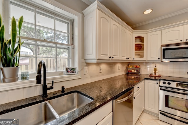 kitchen with sink, white cabinets, stainless steel appliances, and dark stone countertops