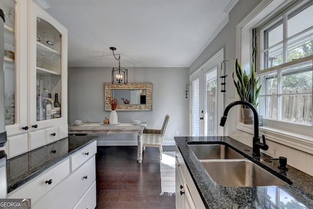 kitchen featuring sink, white cabinetry, hanging light fixtures, and a healthy amount of sunlight