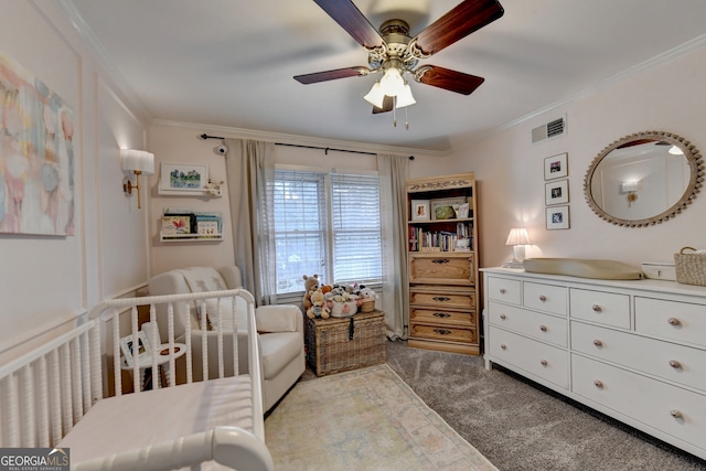 bedroom featuring crown molding, light carpet, a crib, and ceiling fan