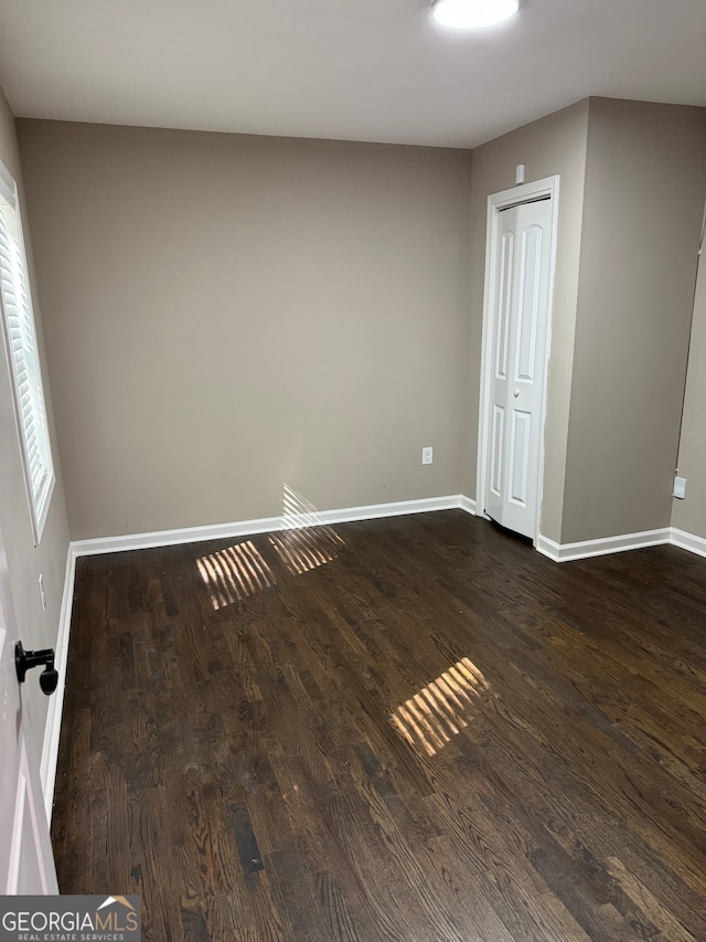 empty room with dark hardwood / wood-style flooring