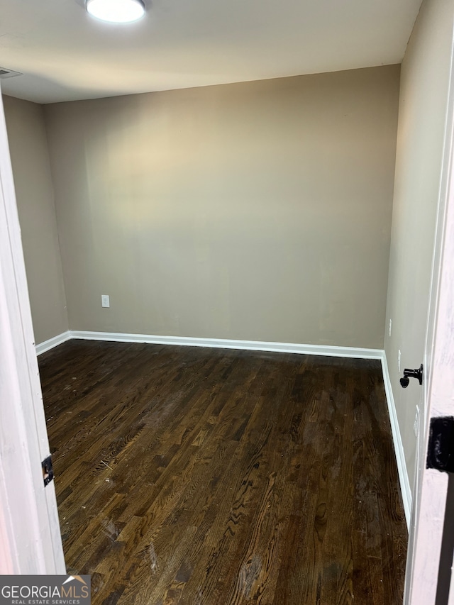 unfurnished room with dark hardwood / wood-style flooring