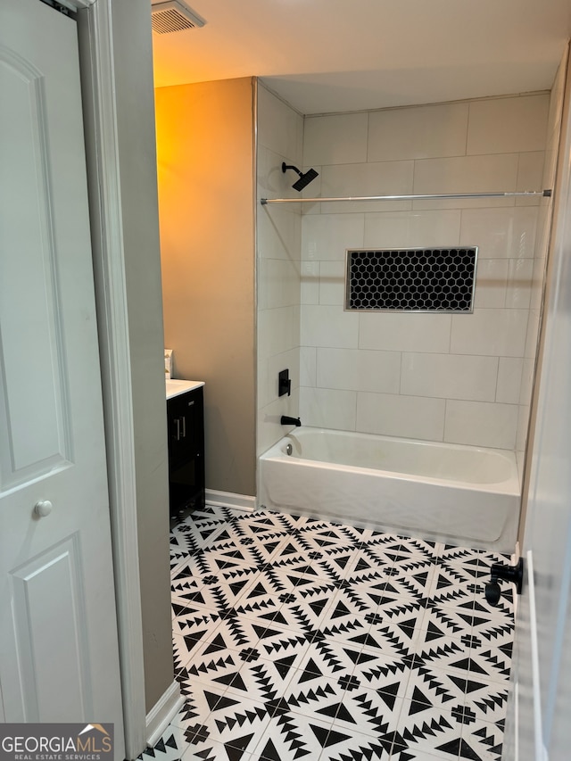 bathroom with vanity, tiled shower / bath combo, and tile patterned flooring