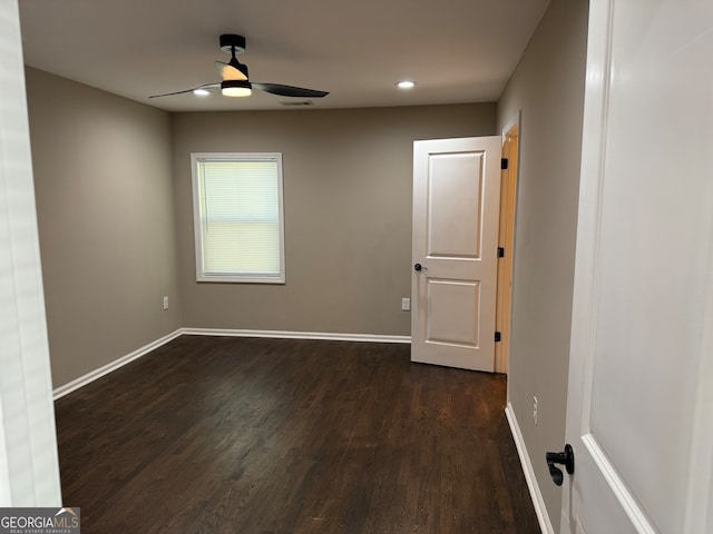 empty room with dark wood-type flooring and ceiling fan