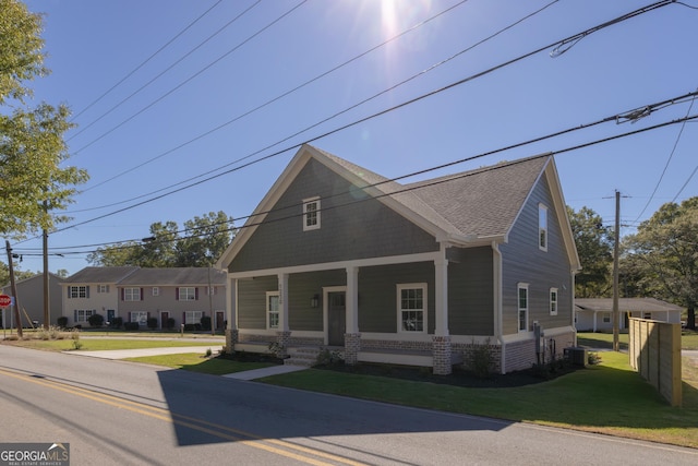 view of front facade with cooling unit, a front yard, and a porch