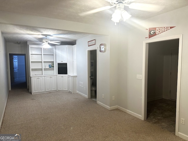 unfurnished living room featuring light carpet, a textured ceiling, and ceiling fan