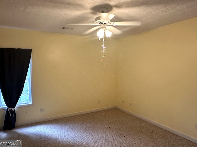 empty room with a textured ceiling, carpet, and ceiling fan