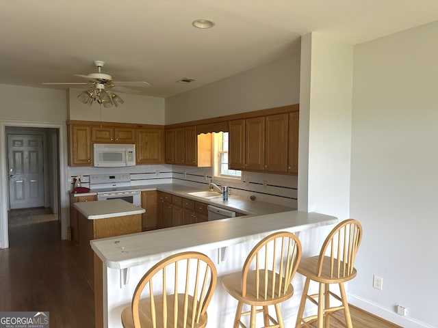 kitchen with kitchen peninsula, ceiling fan, wood-type flooring, and white appliances