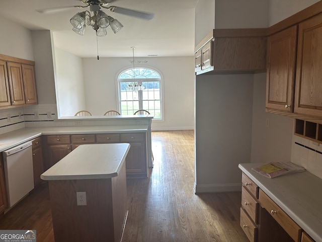 kitchen with backsplash, white dishwasher, a center island, decorative light fixtures, and dark hardwood / wood-style floors