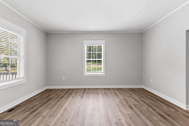 spare room featuring ornamental molding and hardwood / wood-style flooring