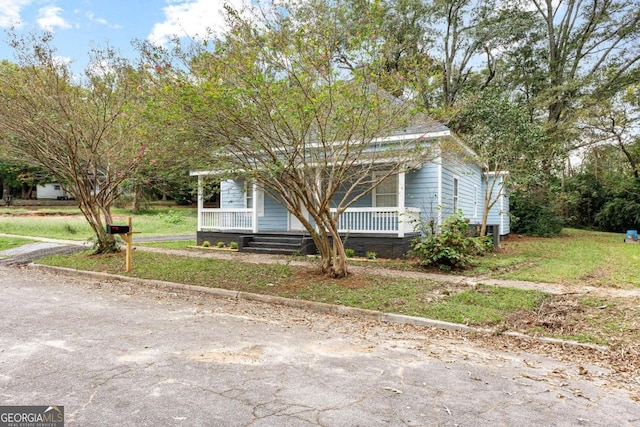 view of front of home featuring covered porch and a front lawn