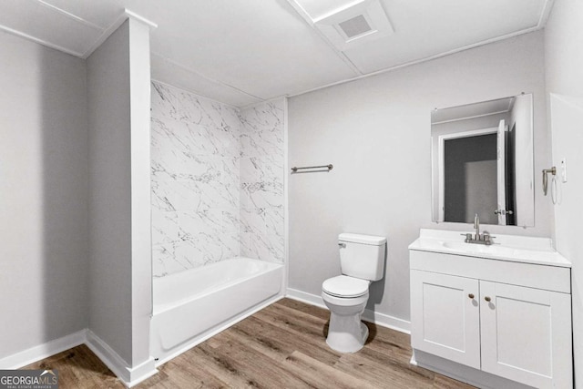 full bathroom with toilet, tiled shower / bath, hardwood / wood-style floors, and vanity