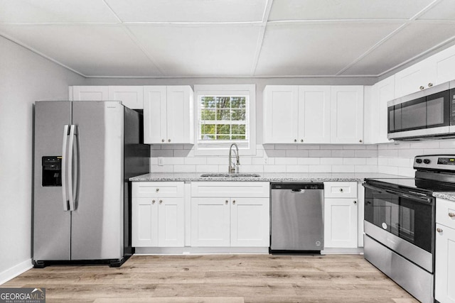 kitchen featuring white cabinetry, stainless steel appliances, sink, and light wood-type flooring